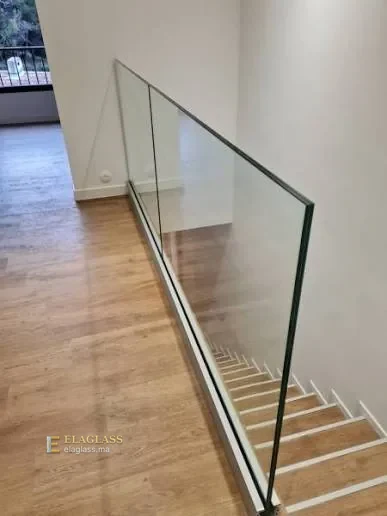 Garde-corps en verre le long d’un palier avec sol en bois